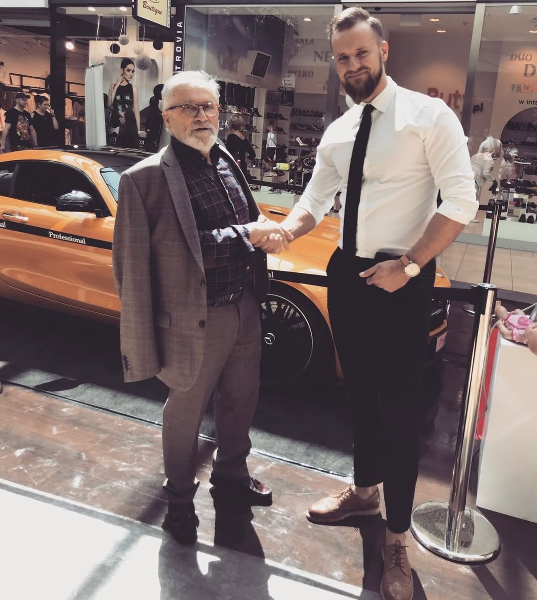 Spotkanie w galerii – uścisk dłoni przy samochodzie pokazowym